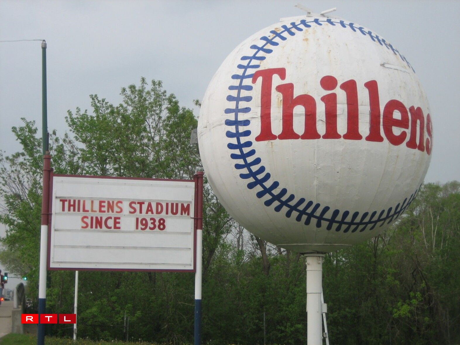 Large Baseball and Sign at Thillens Stadium .