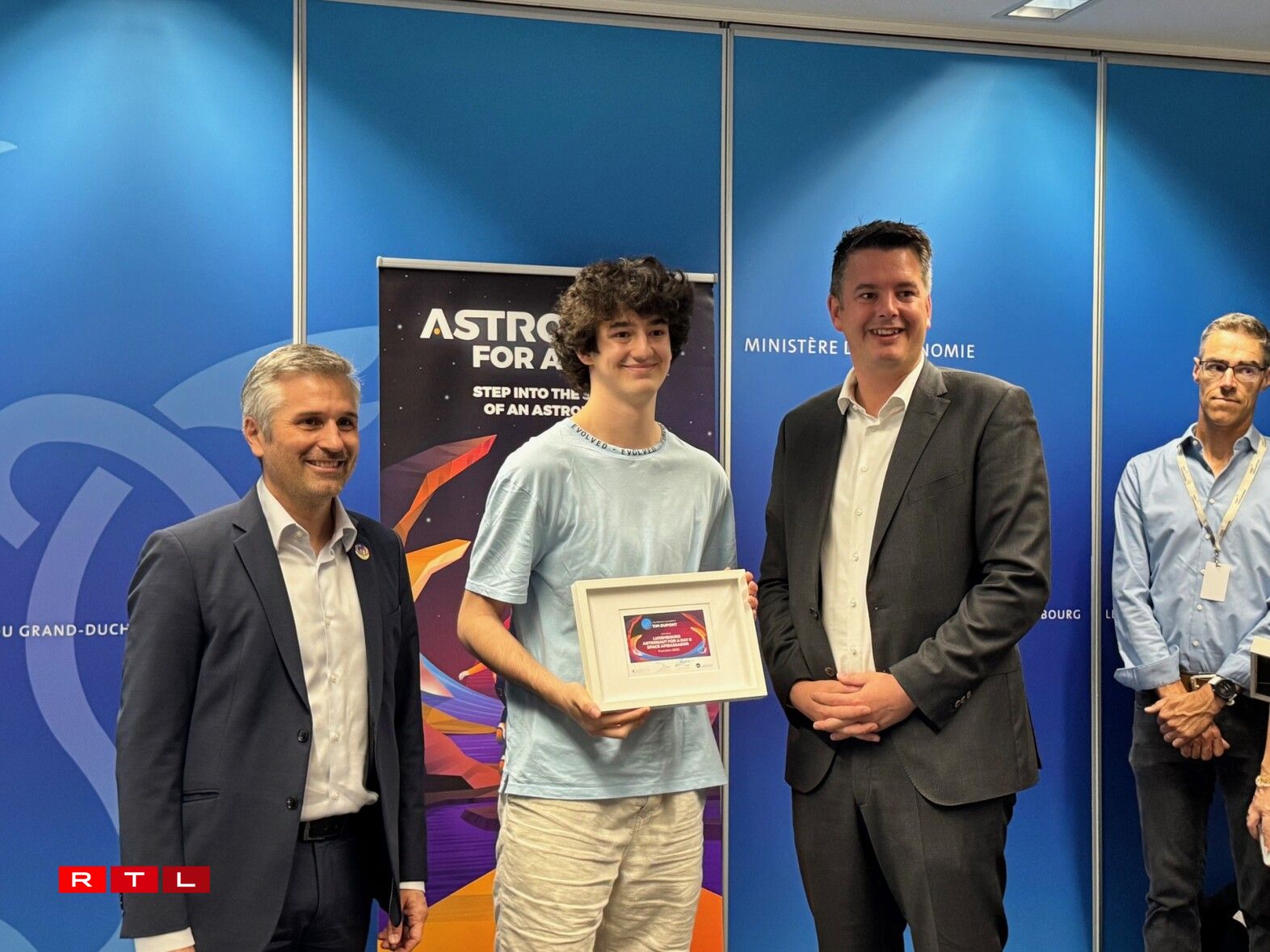 Tim Dupont du Lycée Hubert Clément à Esch reçoit son diplôme en présence du ministre de l'Economie (droite) et du CEO de l'Agence spatiale luxembourgeoise (gauche)