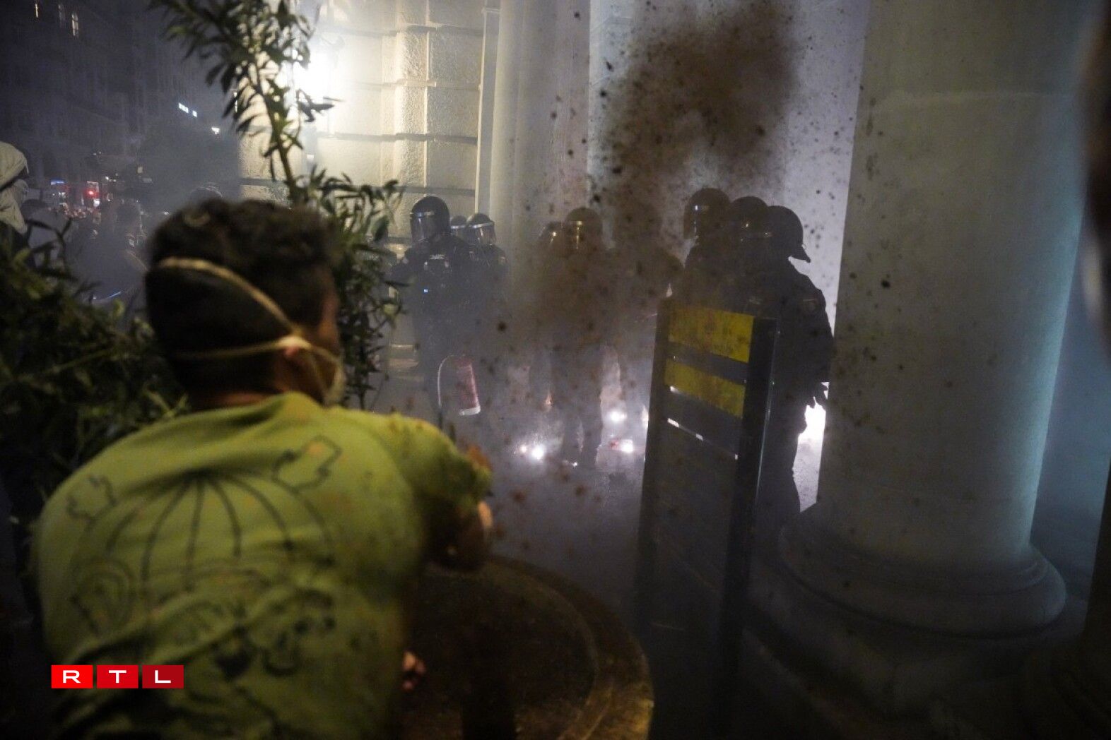 Des manifestants jettent de la terre sur des policiers en tenue anti-émeute lors d'une manifestation pour exiger la démission du président régional de Valence, Carlos Mazon.