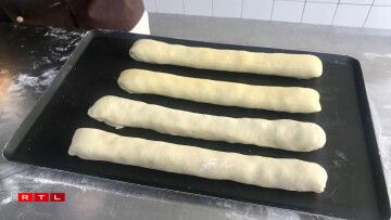 La pâte est roulée autour et celée avec du jaune d'oeuf.