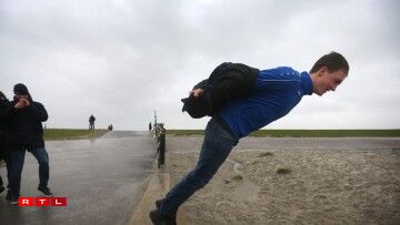 A man stand on the edge of a seawall during Storm Ciara in Harlingen on February 9, 2020, which has brought unusually high winds across Europe with many countries cancelling national and international sport events.