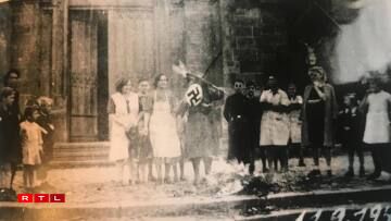 Residents burning Nazi flags in front of the church.