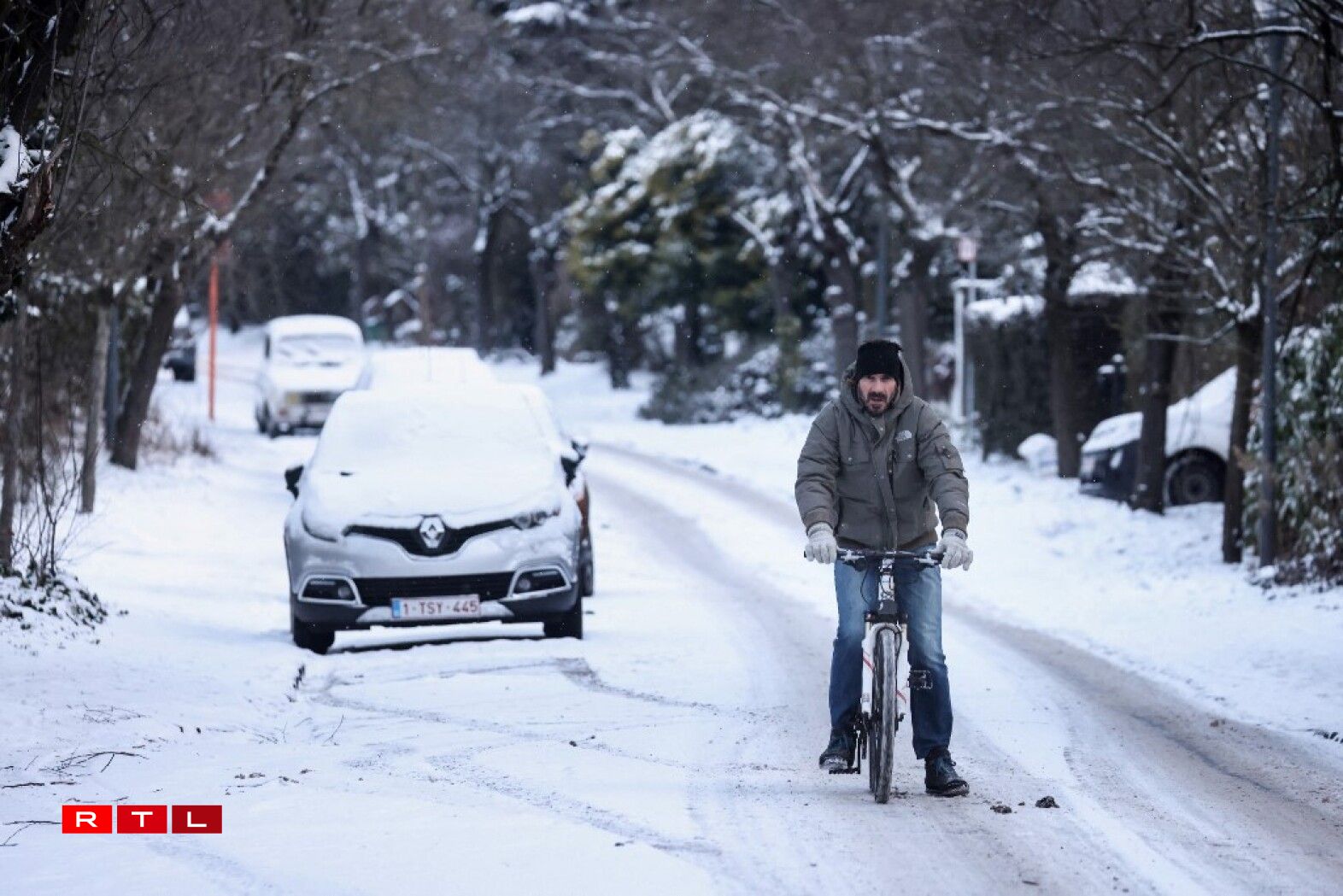 Un homme se déplaçant à vélo à Bruxelles après d'importantes chutes de neige.
