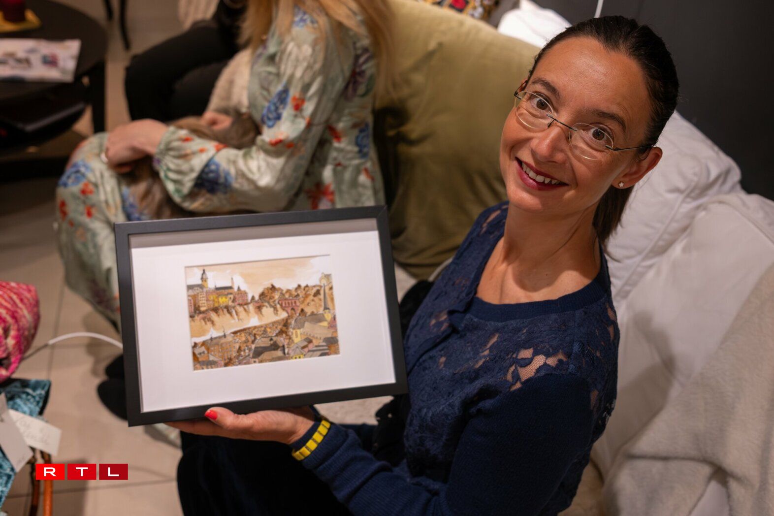 D'Sara Colzani mécht faarweg Poschen an illustréiert och. Si weist eis eng vun hiren Illustratioune vun der Stad Lëtzebuerg - mat Kaffi gemaach.