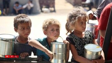 Des enfants attendent que de la nourriture soit distribuée dans un camp de déplacés à Khan Younès, dans le sud de la bande de Gaza, le 11 juin 2024