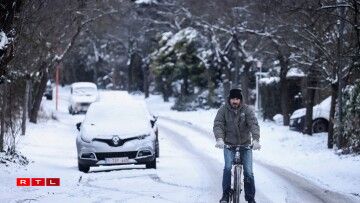 Un homme se déplaçant à vélo à Bruxelles après d'importantes chutes de neige.
