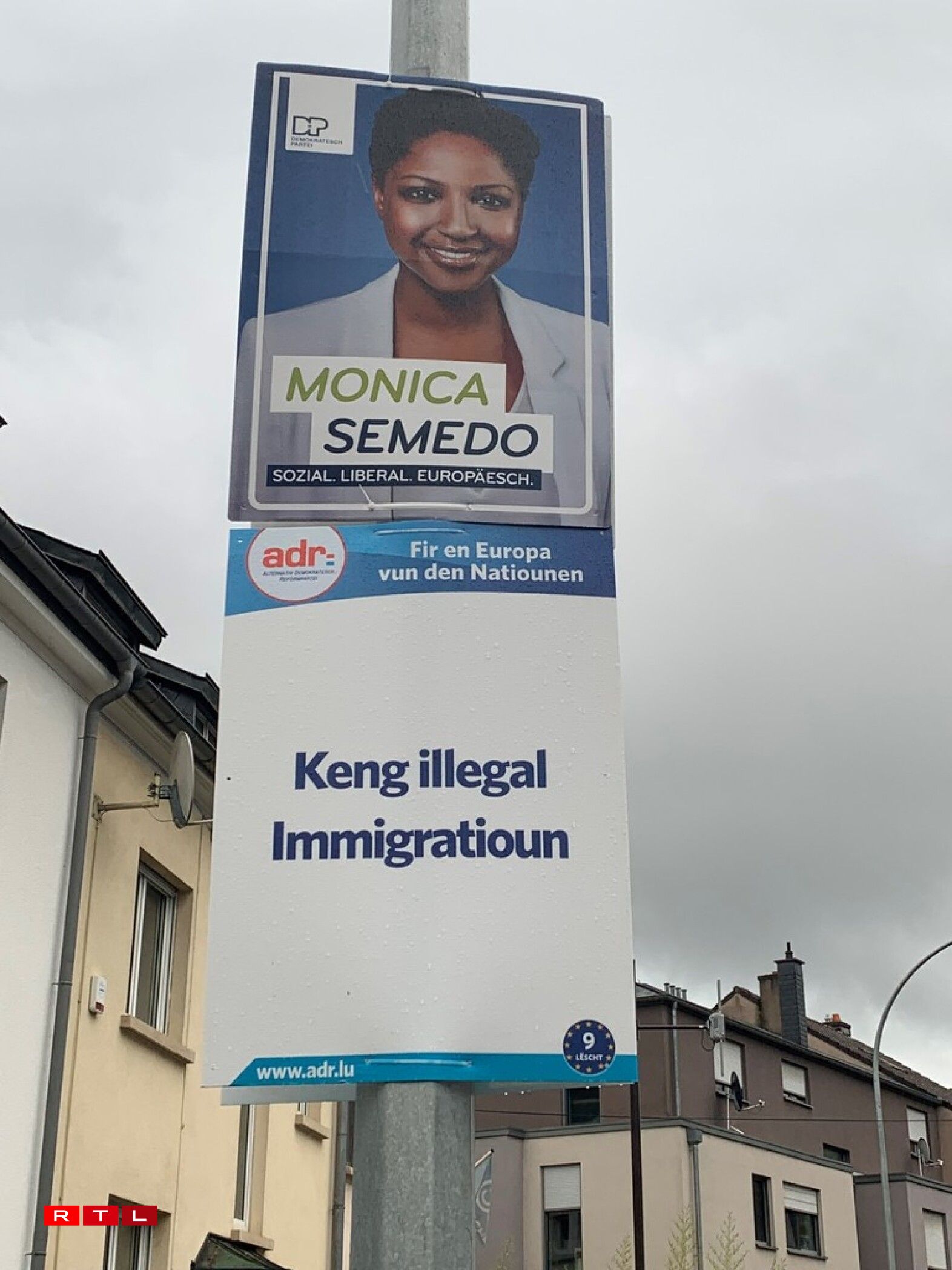 Am Rollengergrënn hänken déi Plakater nach zesummen op engem Luuchtepotto.