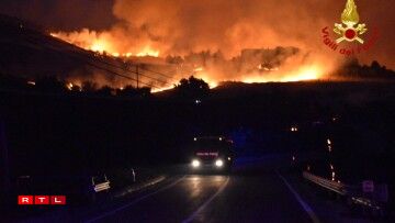 Les pompiers foncent pour combattre un incendie à proximité de la ville de Palerme le 10 août 2021