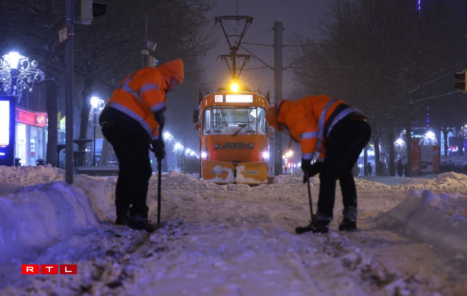 Des ouvriers en train de déneiger la voie du tram à Magdebourg.