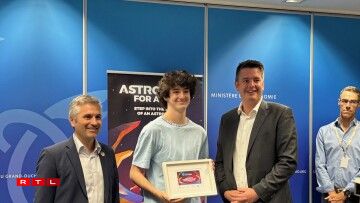 Tim Dupont du Lycée Hubert Clément à Esch reçoit son diplôme en présence du ministre de l'Economie (droite) et du CEO de l'Agence spatiale luxembourgeoise (gauche)