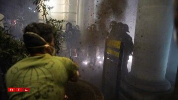 Des manifestants jettent de la terre sur des policiers en tenue anti-émeute lors d'une manifestation pour exiger la démission du président régional de Valence, Carlos Mazon.