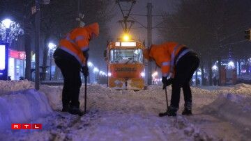 Des ouvriers en train de déneiger la voie du tram à Magdebourg.