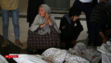 Des parents des victimes d'un attentat contre une école à Kaboul auprès de leurs corps le 8 mai 2021
