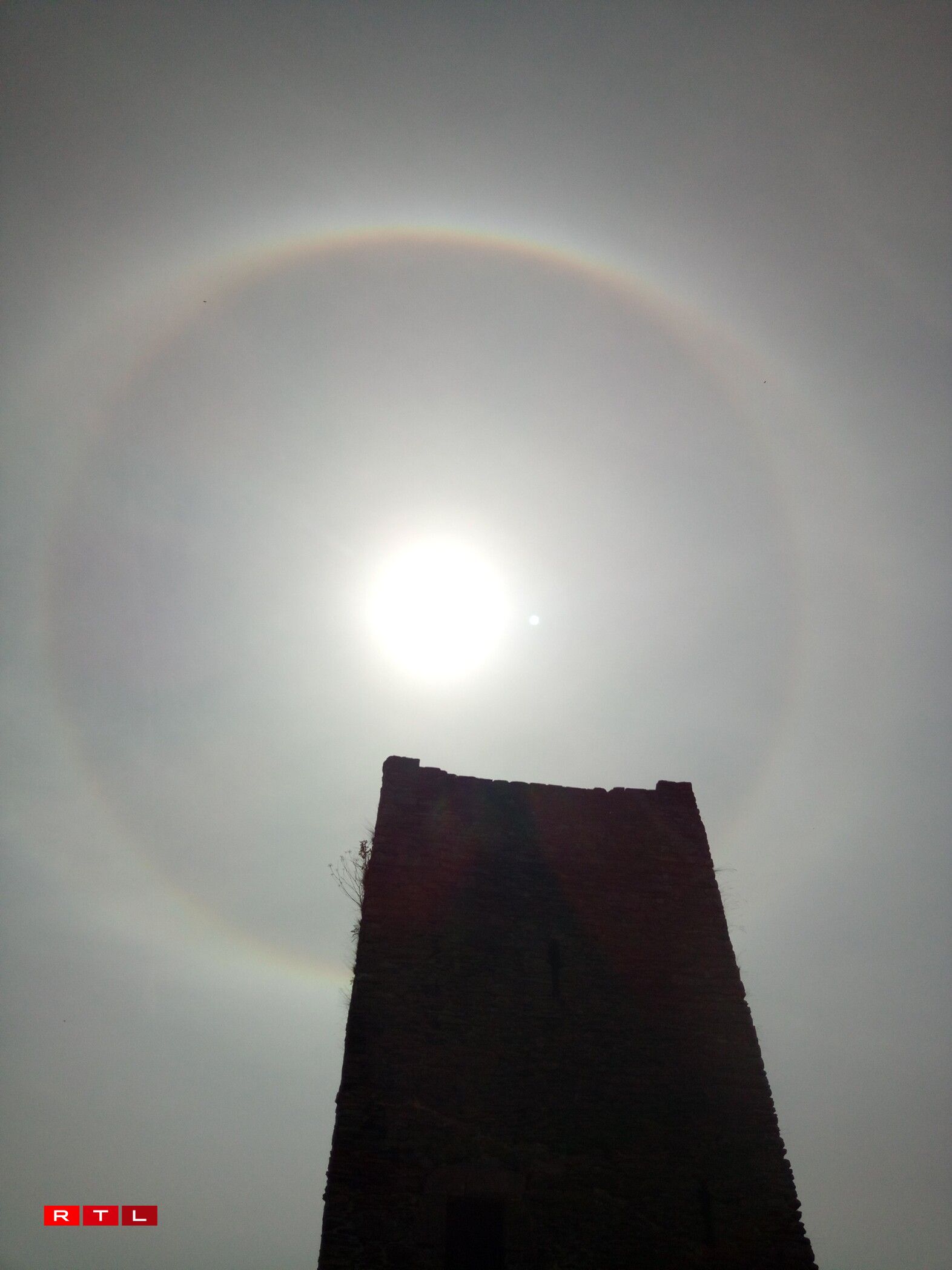 D'Sonn schwieft wéi eng Kugel iwwert dem Tuerm vun der Buerg Branebuerg.